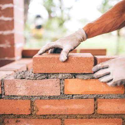 depositphotos_118621020-stock-photo-professional-construction-worker-laying-bricks